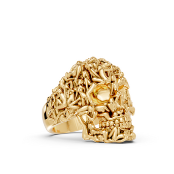 Gold skull-shaped ring on a white background