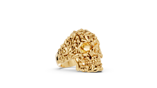 Gold skull-shaped ring on a white background