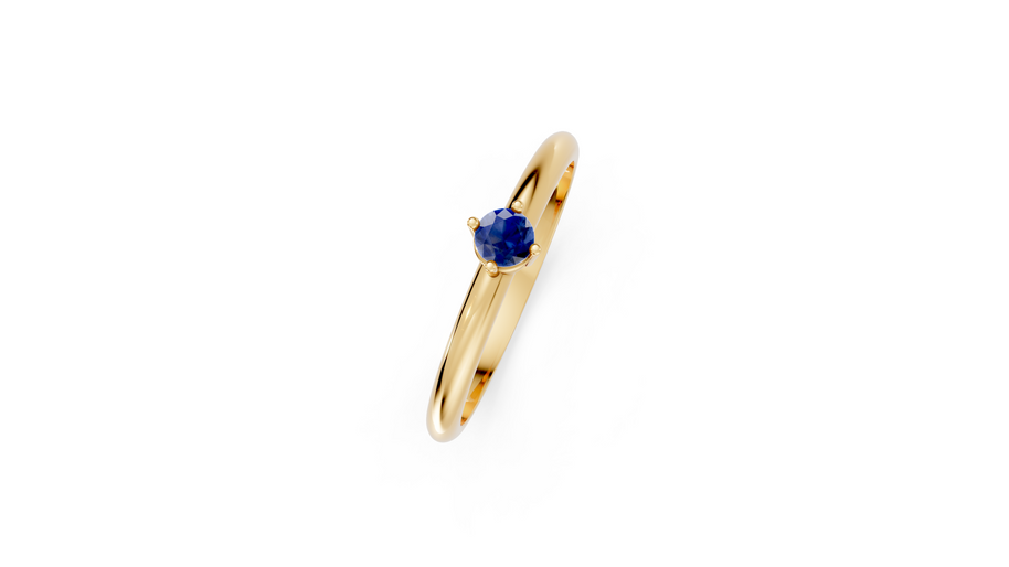 Gold ring with a blue gemstone on a white background