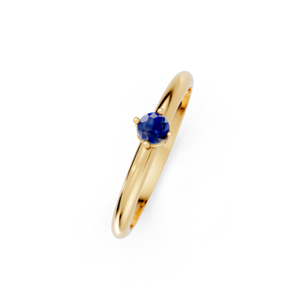 Gold ring with a blue gemstone on a white background