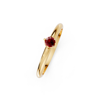 Gold ring with a red gemstone on a white background