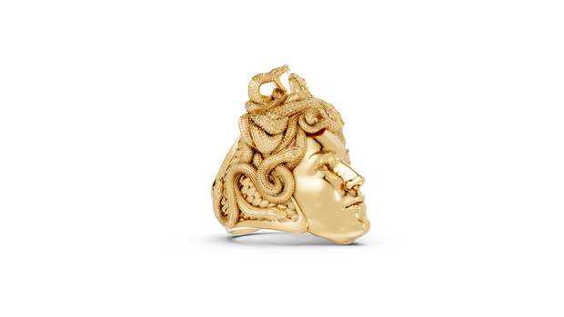 Gold skull pendant with intricate designs on a white background