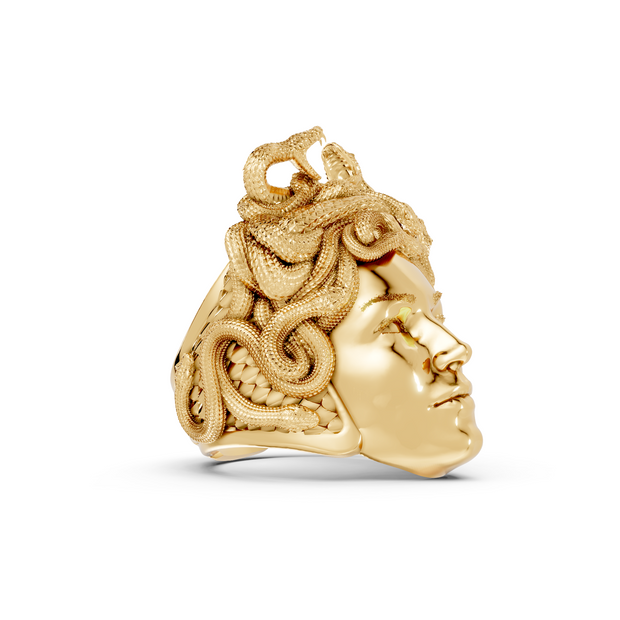Gold skull pendant with intricate designs on a white background