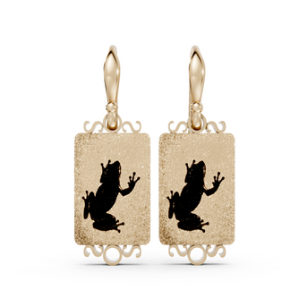 Gold earrings with black frog designs on a white background