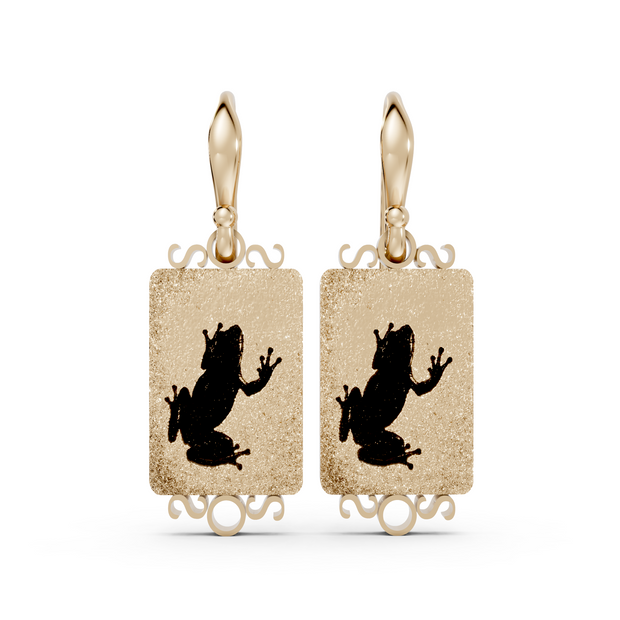 Gold earrings with black frog designs on a white background