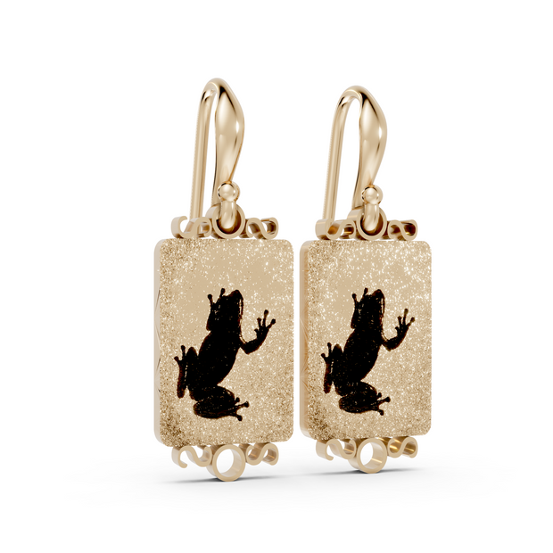 Gold earrings with black silhouette design on a white background