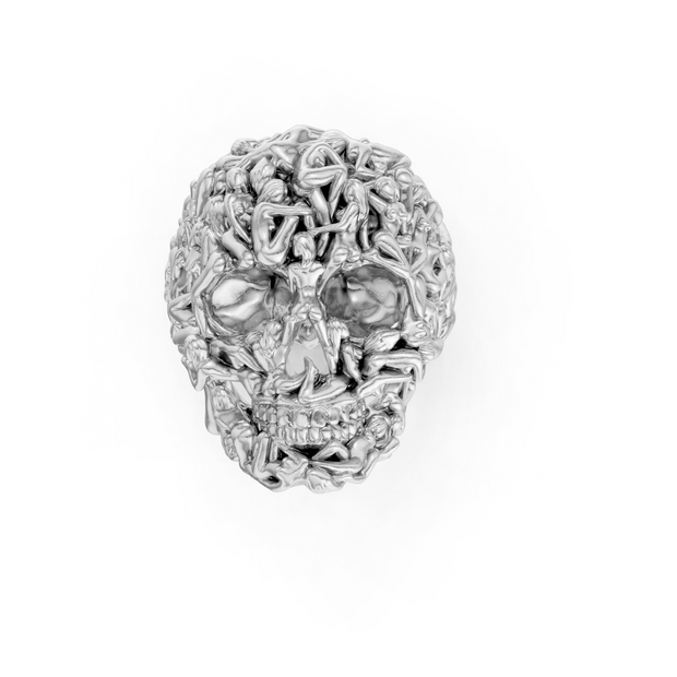 Silver skull-shaped pendant with intricate designs on a white background